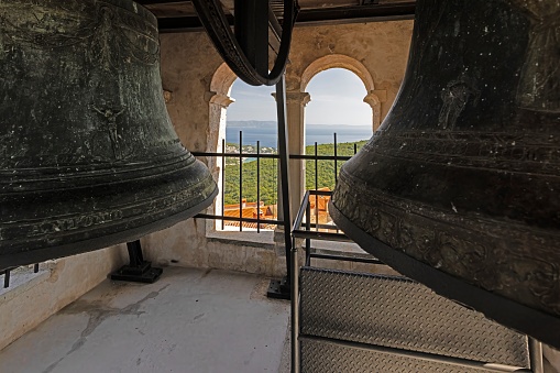 Picture of bronze bells in a bell tower of a historic church in Kratia during the day