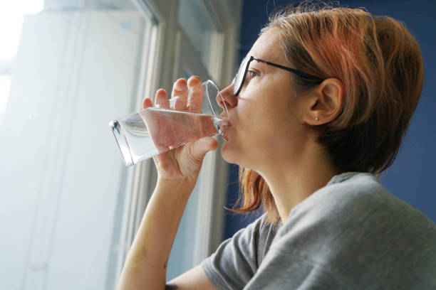 istock Young woman drinking glass of water 1798618727