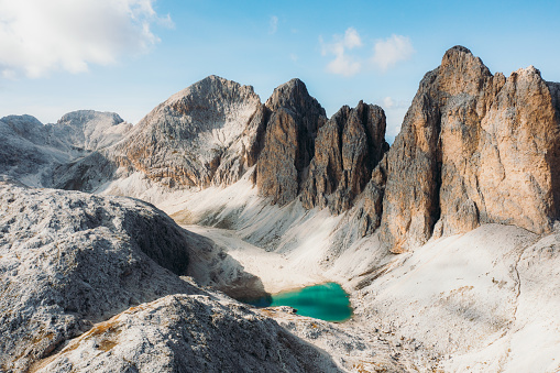 Drone high0angle photo footage of crystal blue mountain lake - Lago Di Antermoia, surrounded by the high rocky peaks of Dolomites Alps - UNESCO World Heritage