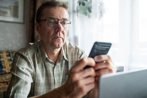 istock Worried senior man looking at smartphone at home 1798623133