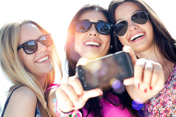istock three friends taking photos with a smartphone 179862805