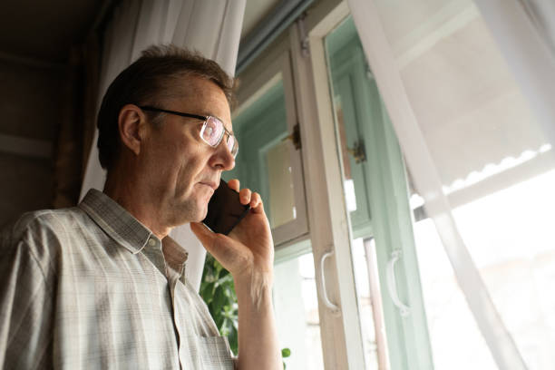 istock Senior man talking by phone at home 1798631081