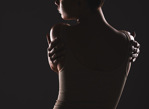 Beauty, back and dark with a model woman posing in studio on a black background for artistic body positivity. Wellness, health and art with a young female standing to promote self love or self care