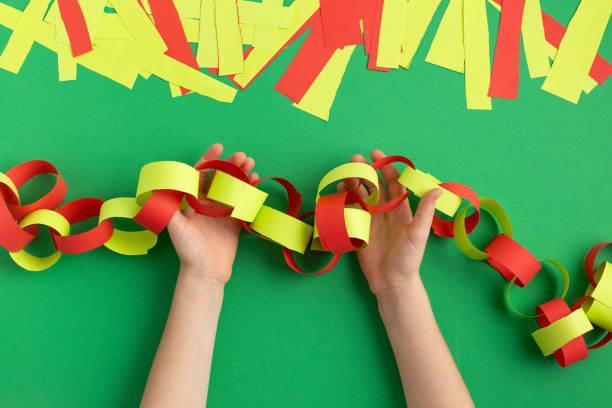 girl hands making paper chain for new year christmas decoration dyi easy occupation at home stock photo