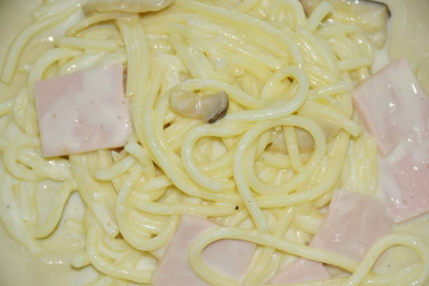 gedämpfte spaghetti weiße cabonara sahnesauce topping slice schinken schweinefleisch - pasta cabonara stock-fotos und bilder