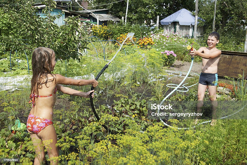 As crianças brincam com mangueiras de jardim - Foto de stock de Alegria royalty-free