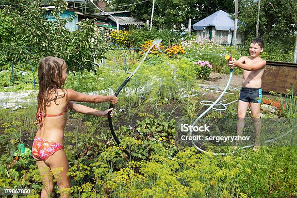 Foto de As Crianças Brincam Com Mangueiras De Jardim e mais fotos de stock de Alegria - Alegria, Amizade, Bebida gelada