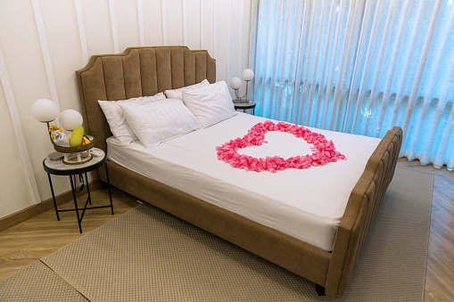Bed room in luxury honeymoon sweet suits. Honey moon bed. Honeymoon, Wedding bed topped with rose and marigold petals