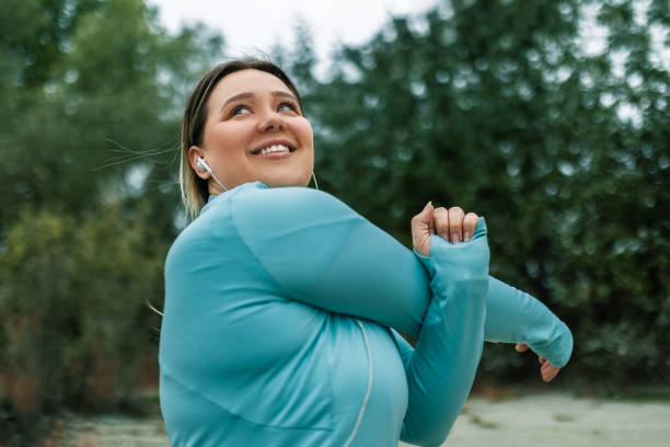 mujer joven abrazando el bienestar - overweight women weight loss fotografías e imágenes de stock