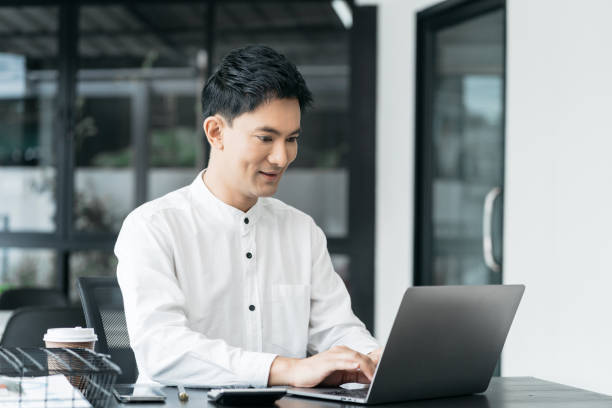 istock Businessman using laptop computer in office. Happy man, entrepreneur, small business owner working online. 1798682882
