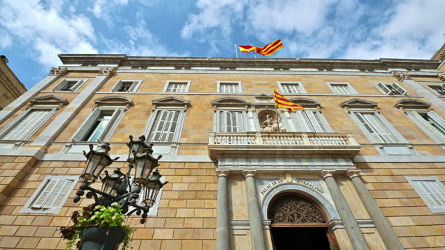 Close view of the Palau de la Generalitat de Catalunya facade with national flags in Spain