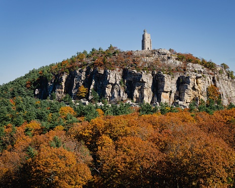 Mohunk, United States – October 29, 2022: A vintage stone lighthouse against the horizon in the Mohonk Preserve