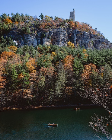 Mohunk, United States – October 29, 2022: Aerial view of a lake situated in the Mohonk Preserve surrounded by cliffs in autumn