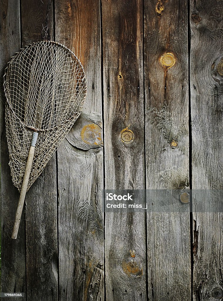Fishing net An old fishing net hanging on rustic wooden wall Fishing Industry Stock Photo