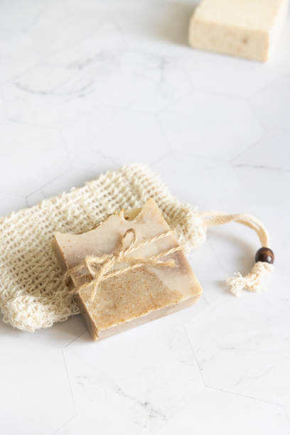 istock Beige handmade soap bar on soap saver bag on a marble table close up, mockup 1798696710