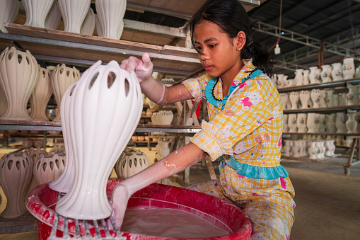 A girl is making pottery vase in a pottery factory in Tay Ninh province, South Vietnam