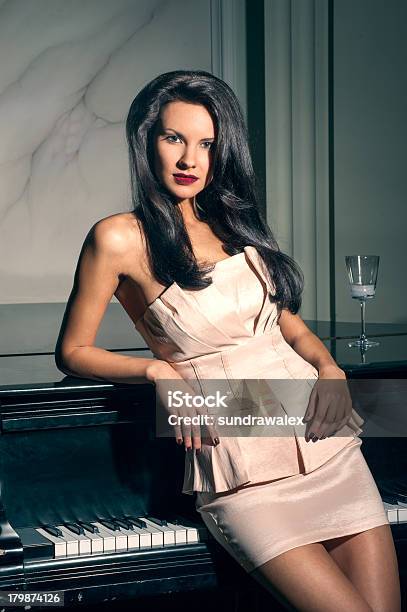 Retrato De Un Elegante Brunette En El Piano Foto de stock y más banco de imágenes de Adulto - Adulto, Anochecer, Belleza