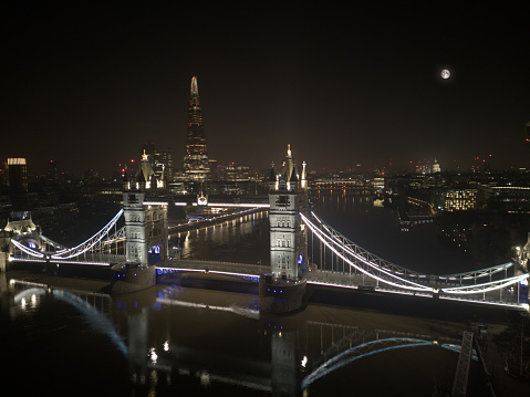 Aerial view of London's Tower Bridge at night with St Paul's Cathedral and panorama of city of London (landscape)