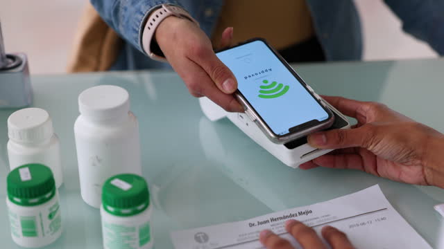 Close up of a woman making a mobile payment for medicines at the pharmacy