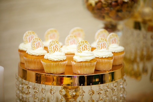 Beautiful and bright desserts on the festive table for the party. Confectionery with cream and marzipan.