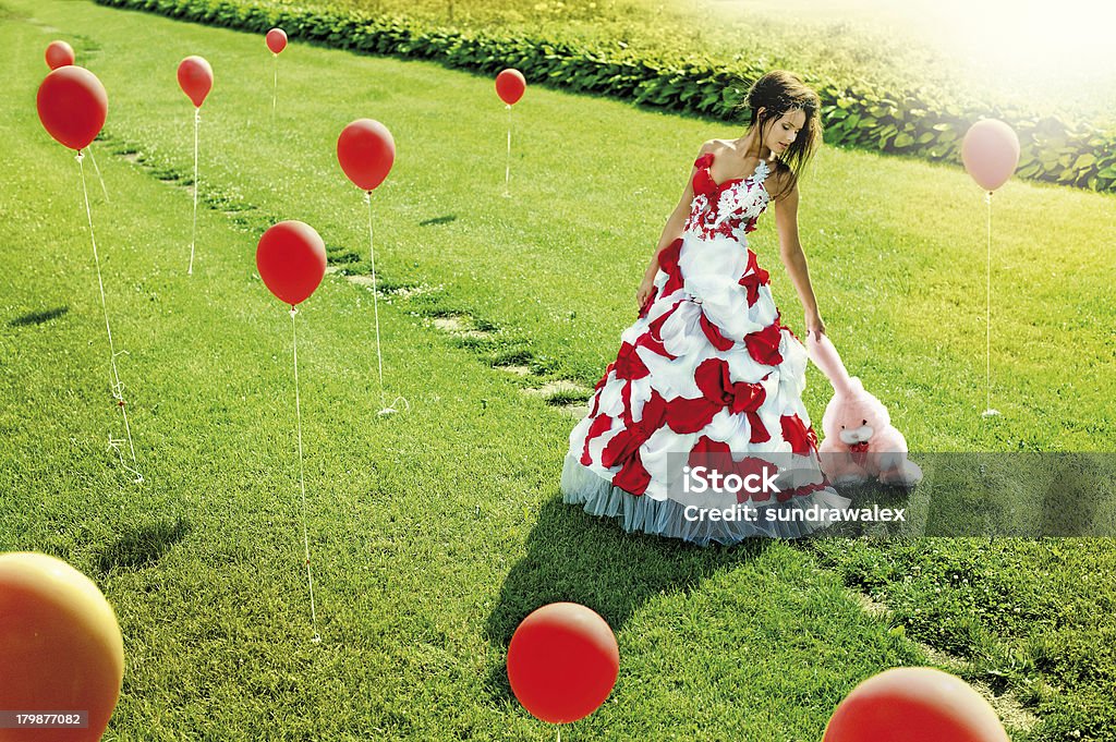 Bella giovane ragazza in piedi nel mezzo del campo palline - Foto stock royalty-free di Abbigliamento