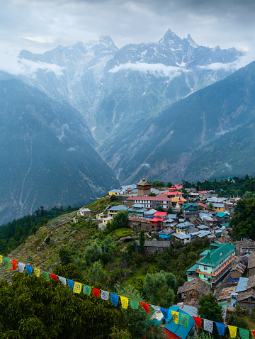 Kalpa village nestled in valley flanked by Himalayas shrouded in mist and cloud on a beautiful morning. Kalpa, Himachal Pradesh, India.