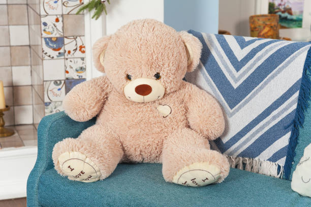 istock A large lonely ivory-colored teddy bear sits on the sofa in the apartment. 1798805607