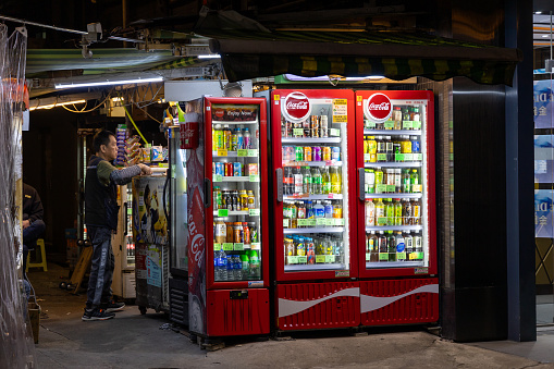 Hong Kong - November 17, 2023 : Beverages in refrigerators at a street vendor stall in Mong Kok, Kowloon, Hong Kong.