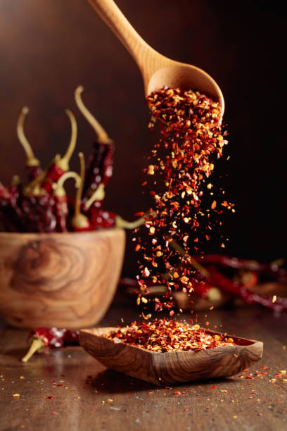 istock Chilli flakes are poured into a wooden dish. 1798847765
