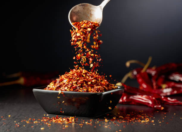 istock Chilli flakes are poured into a black dish. 1798847775
