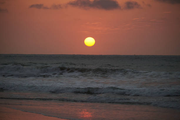 Sunset on the beach in Tumbes, Peru with waves and sand.