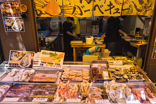 Tokyo, Japan - April 12, 2023: street food stall on Tsukiji Fish Market with unidentified people. It is a major tourist attraction. Before 2018, it was the largest wholesale fish market in the world