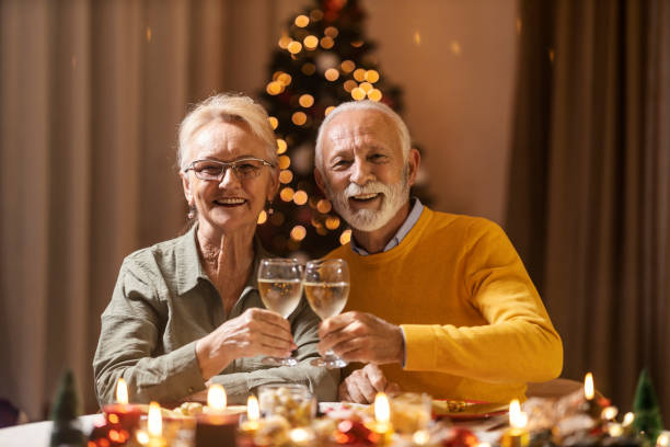 istock A senior couple is toasting with wine while sitting at dining table at christmas and new year's eve. 1798920585