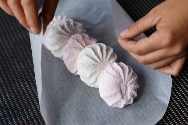 istock White and pink marshmallows on the paper with arm 1798956945
