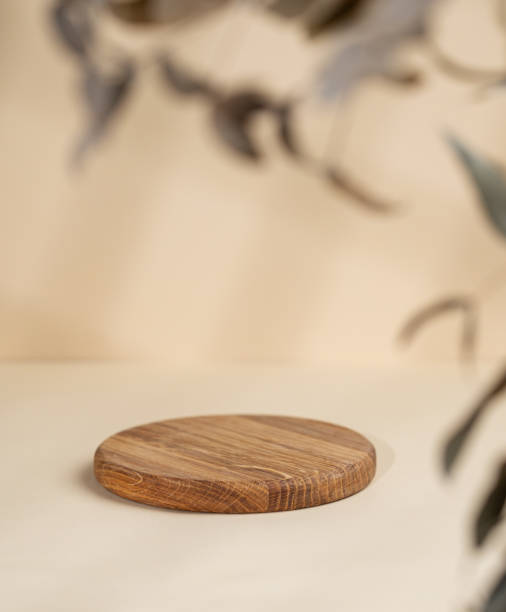 istock Abstract empty wooden round board with shadows and leaves on a beige background. Layout concept for promotional product presentation, sale or cosmetics display. 1798983717