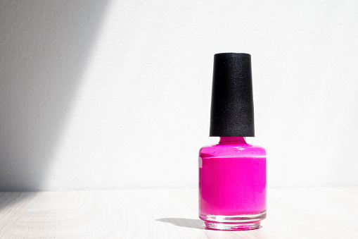 Pink nail polish on the table.