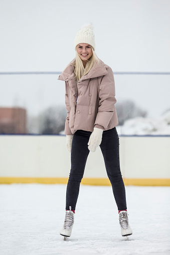 Happy Caucasian Girl  in Winter With Ice Skates On Snowy Winter Landscape Outdoor. Vertical image Composition