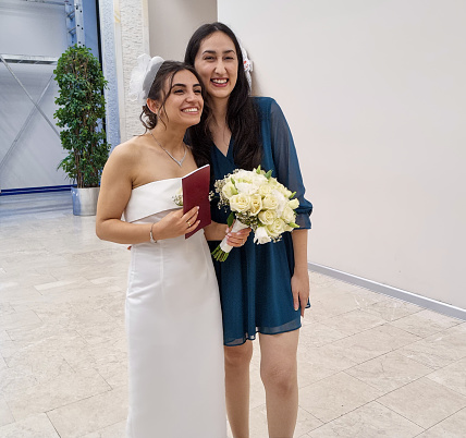Young lesbian couple standing together and celebrating their wedding
