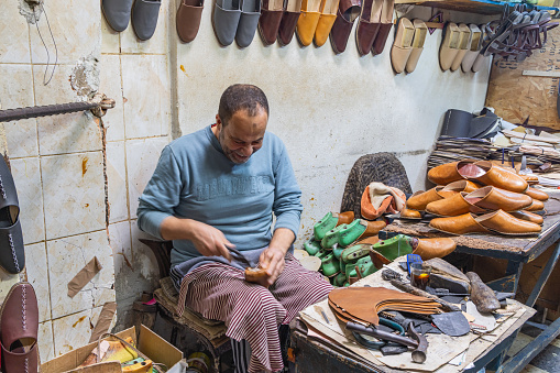 Kairouan, Tunisia. March 14, 2023. Shoemaker working in his shop.