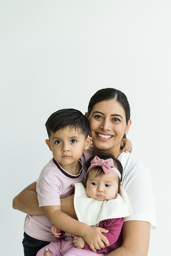 Young mother with toddler boy and baby girl. Latin Family