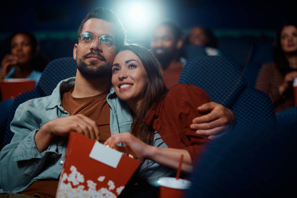 istock Young couple eating popcorn while watching movie in cinema. 1799054456