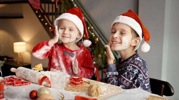 istock Two funny boy getting dirty and messy in flour while cooking on kitchen Christmas pie and cookies 1799060324
