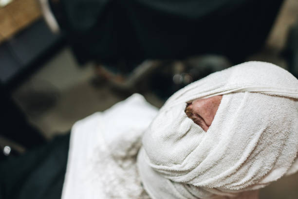 Man's head wrapped with a towel in a barber shop