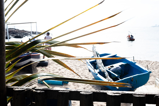 Salvador, Bahia, Brazil - January 30, 2022: Fishermen are seen on the Rio Vermelho beach next to boats in the city of Salvador, Bahia.