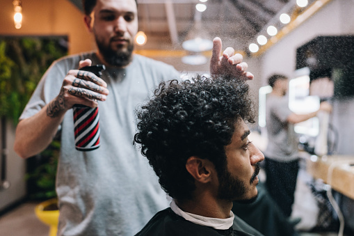 Barber spraying a customer's hair in a barber shop