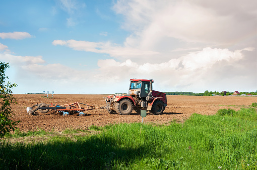 The tractor plows the land. Preparation for sowing and planting. Agriculture image.