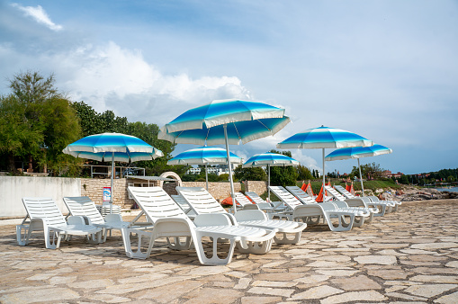Sun loungers on the beach in Europe. Sunny beaches of Croatia.