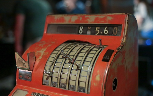 Old red cash register in a shop, close-up of photo