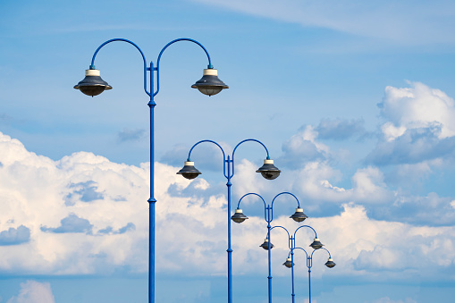 row, blue, painted, lampposts, cloudy, blue sky,