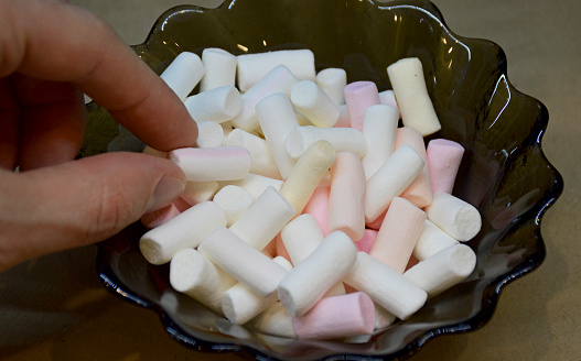 multi-colored marshmallow dessert bars in a glass bowl, close-up. tasty, soft sweetness for children and adults. high-calorie food. unhealthy diet